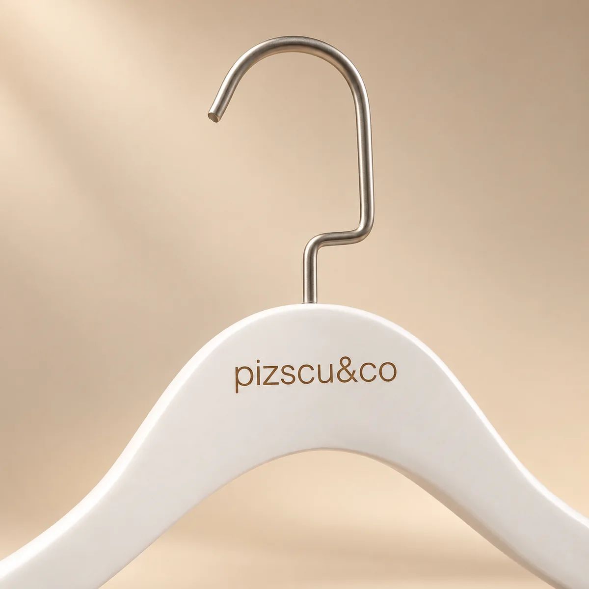 Percha blanca personalizada con logotipo grabado, detalle de acabado