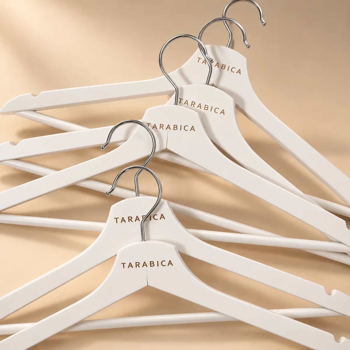 Percha blanca personalizada con prendas ligeras en colores pastel
